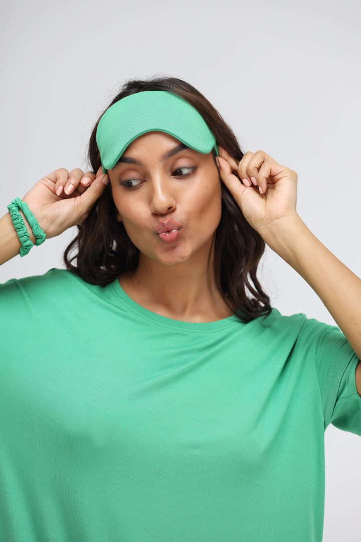 Model wearing a stylish green bee modal t-shirt dress and matching accessories.