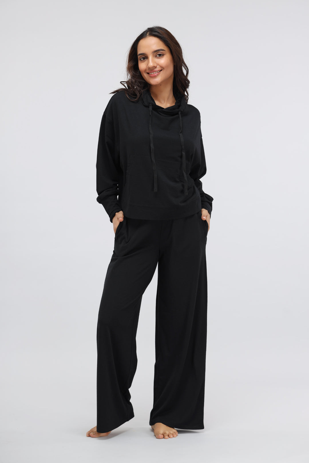 Black Luxflo Travel Hoodie modeled by a woman in stylish black outfit.