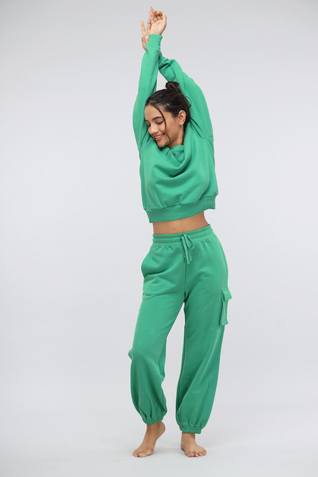 Woman in green relaxed terry sweatshirt and pants, enjoying comfort and style.