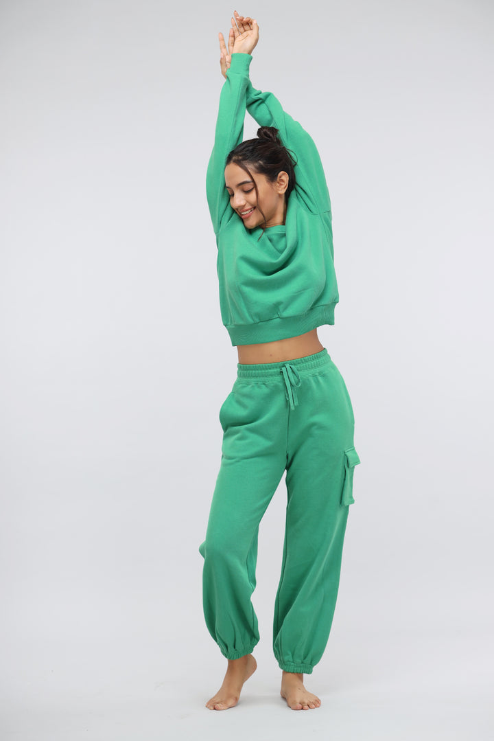 Woman in green relaxed terry sweatshirt and pants, enjoying comfort and style.