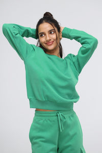 Model wearing a green relaxed terry sweatshirt and matching pants.