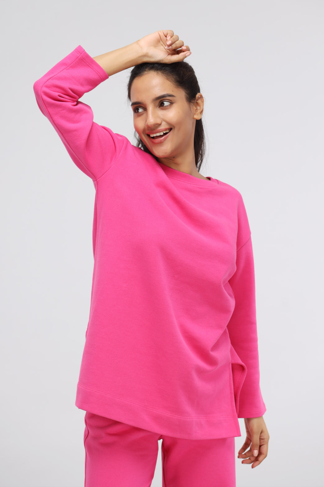 Pink long terry pullover set worn by smiling woman.