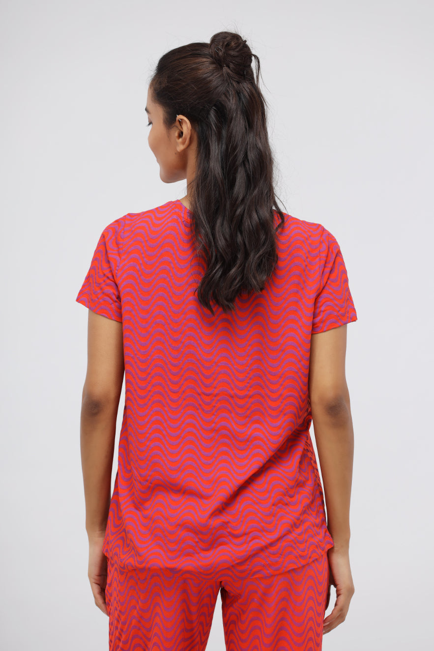 Woman wearing orange wavy soft modal top, stylish and comfortable design.