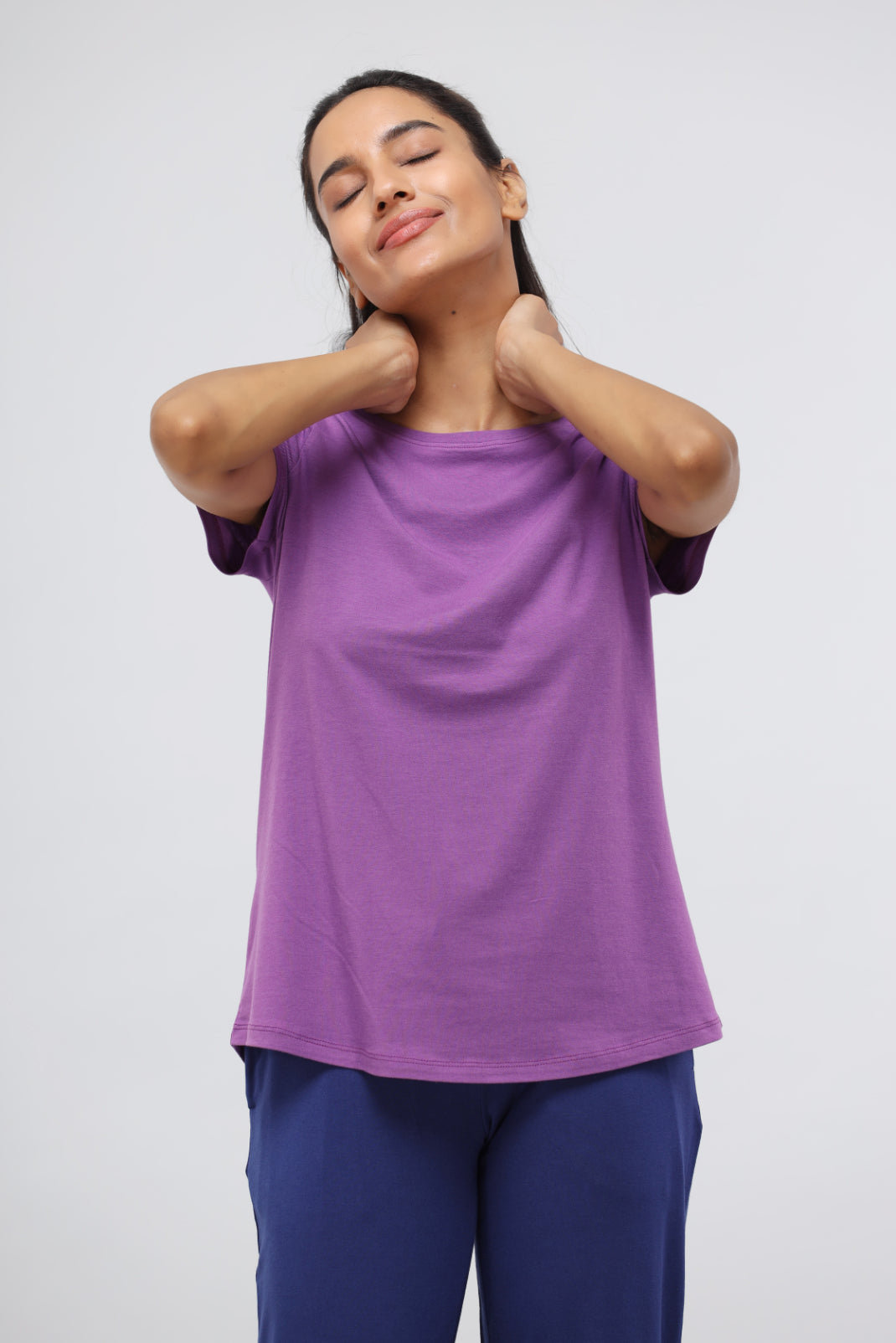 Woman enjoying comfort in purple lounge set, showcasing versatility and style.