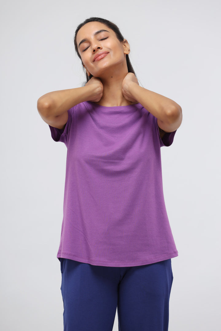 Woman enjoying comfort in purple lounge set, showcasing versatility and style.