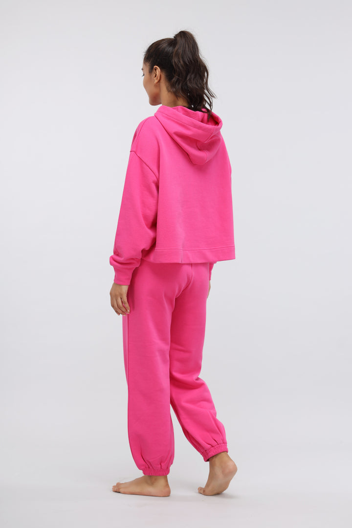 Model wearing pink terry relaxed jogger outfit from the back.