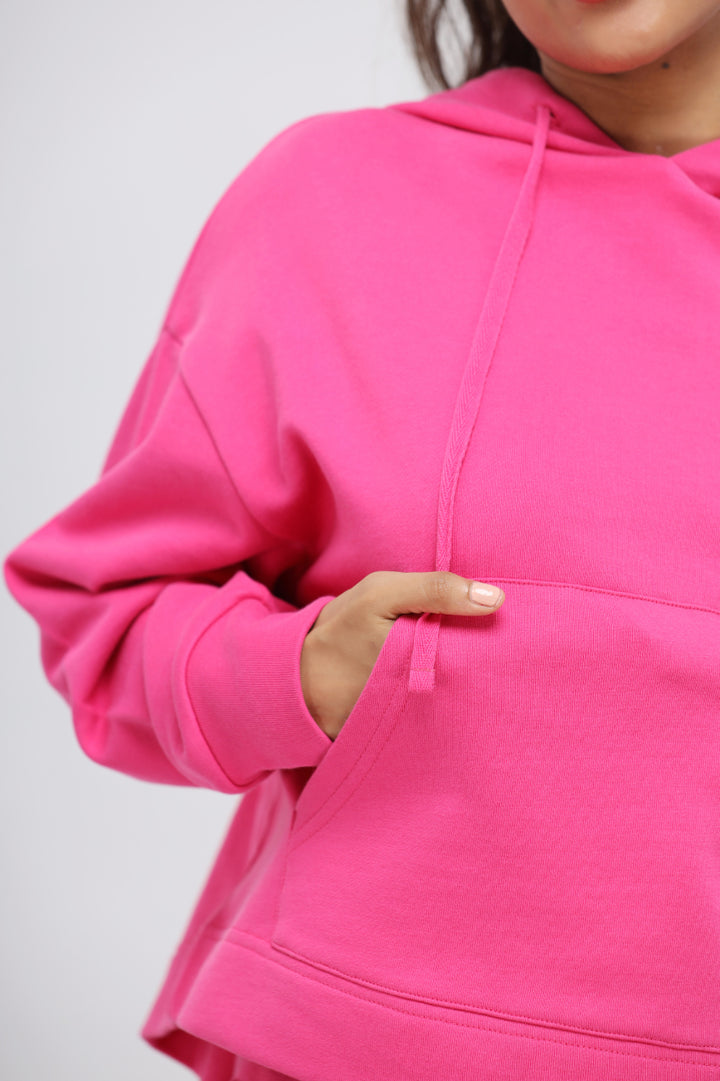 Close-up of a woman wearing a pink cotton terry hoodie.