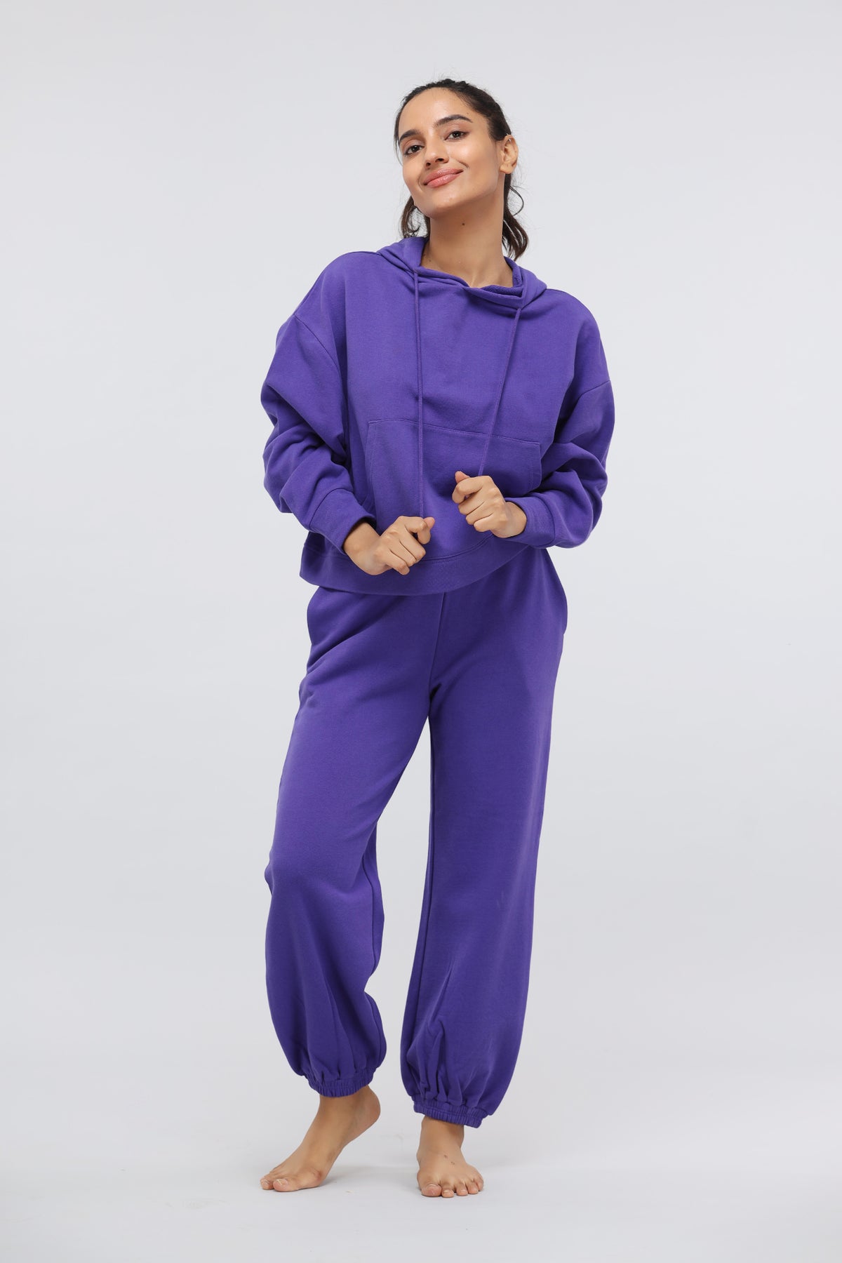 Deep Blue Terry Travel Hoodie in vibrant purple worn by a smiling woman.