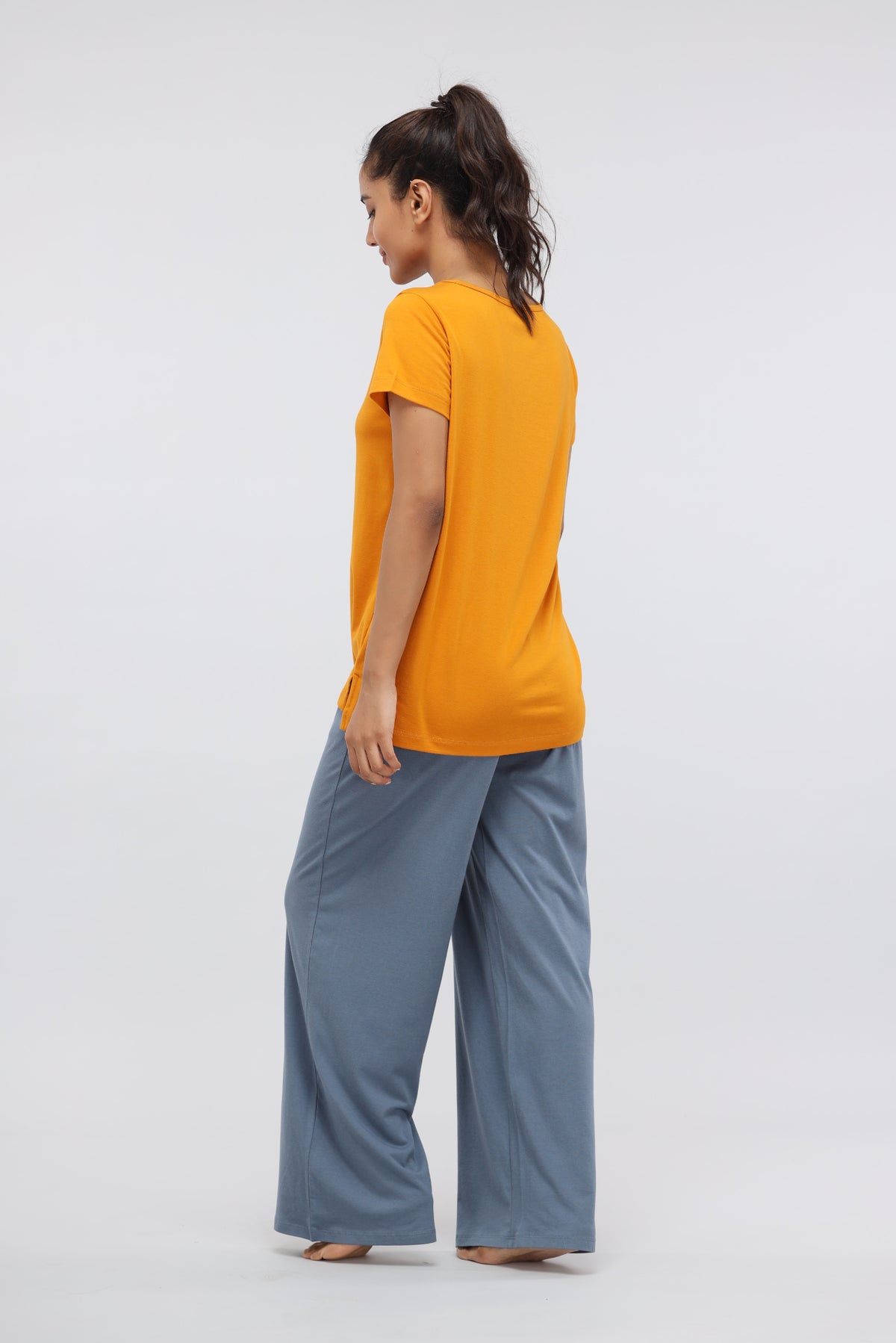Woman wearing China Blue Supima® Flared Lounge Pants with orange top.