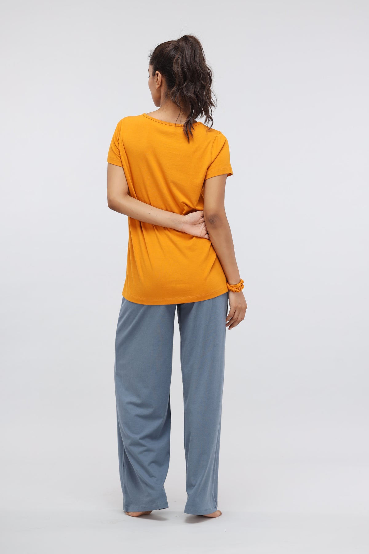 Model wearing Desert Sun Supima® round neck casual top in vibrant orange.