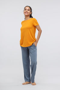 Casual round neck top in vibrant yellow, paired with blue pants.