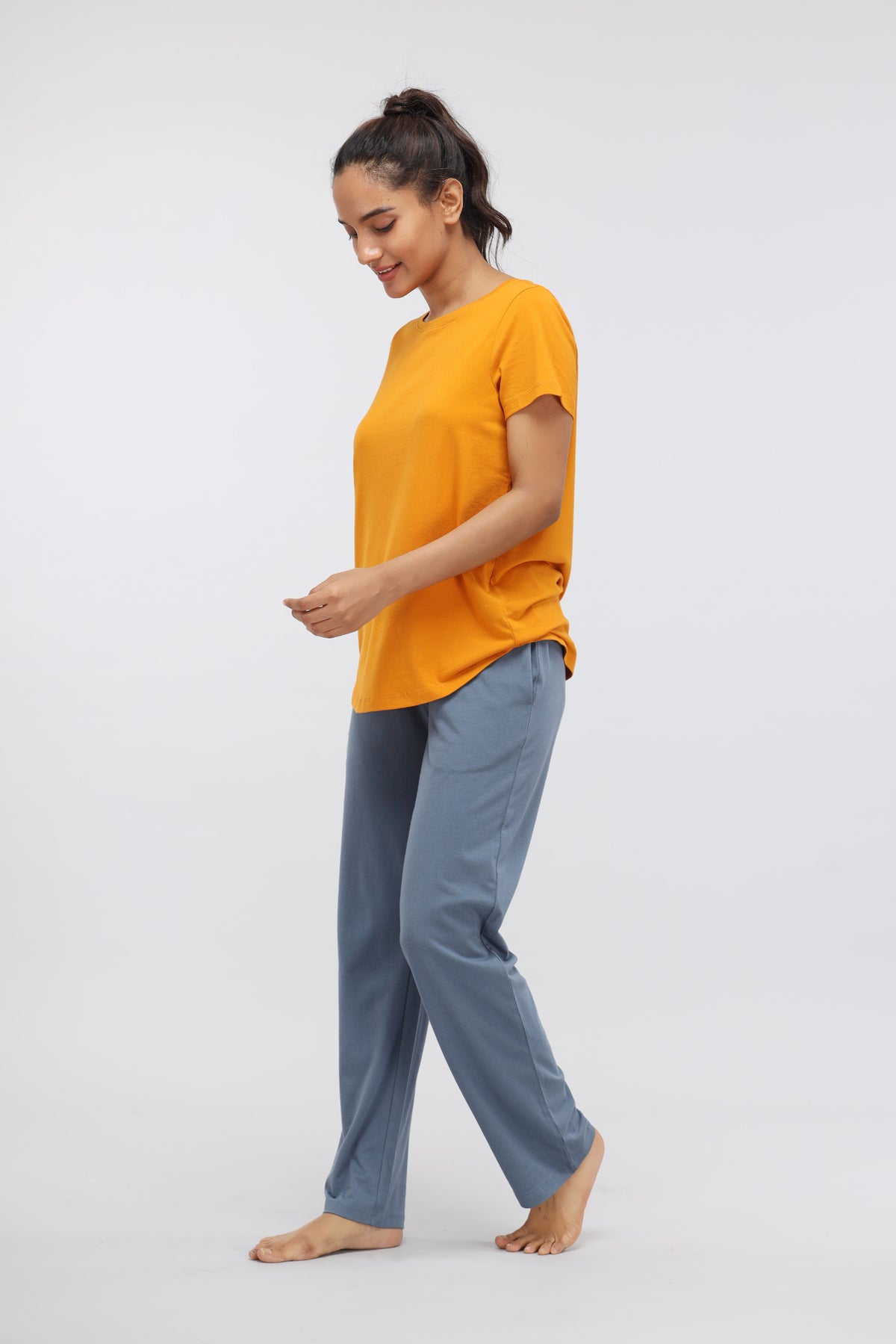 Woman wearing Desert Sun Supima® Round Neck Casual Top in vibrant orange.