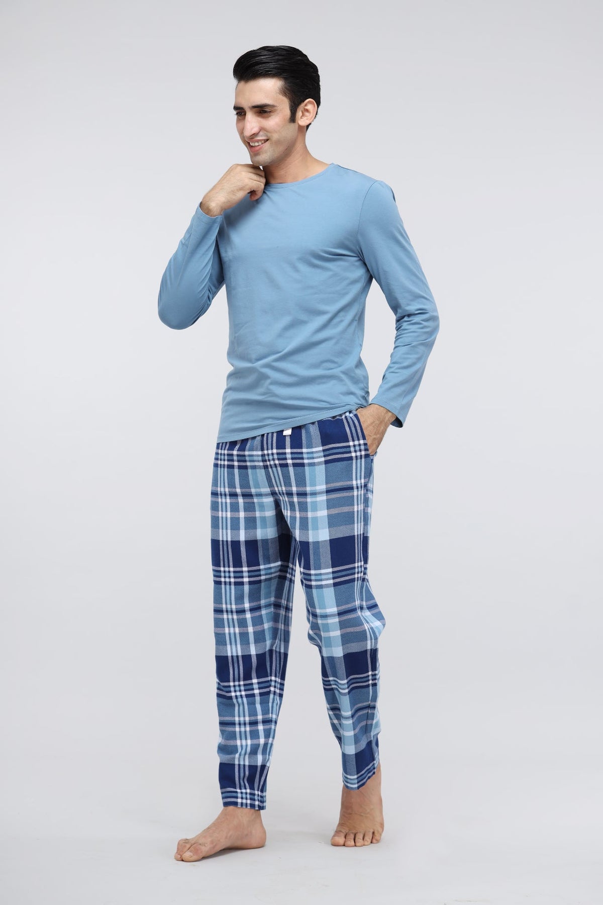 Men's plaid flannel pajamas in blue on a smiling model.