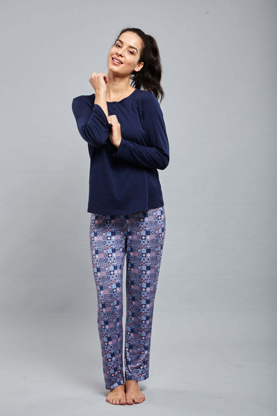 Model wearing Classic Mosaic Pajamas with a navy top and patterned bottoms.