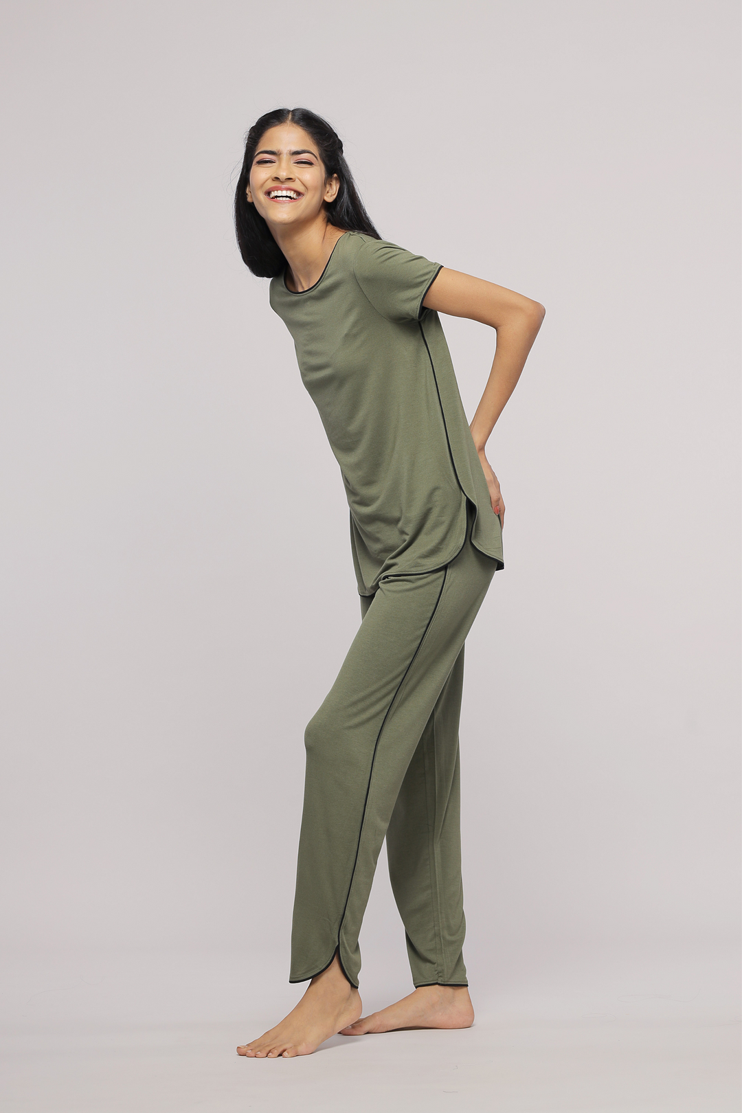 Olive green multipurpose lounge set model smiling in stylish outfit.