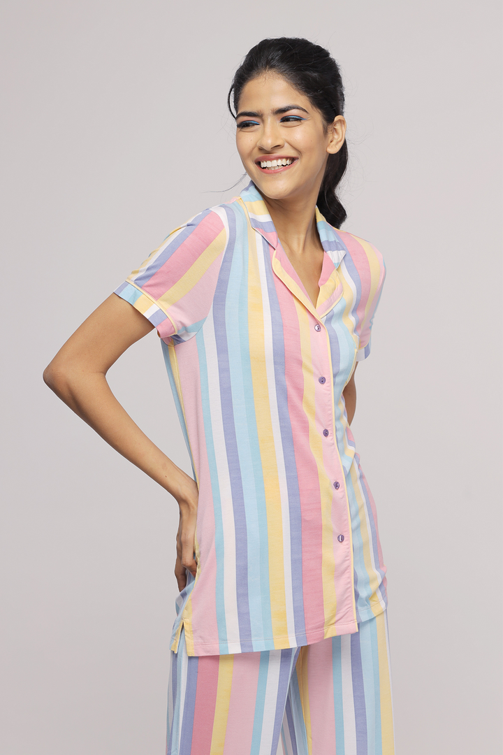 Pastel stripe pajama set on a model, smiling and posing.