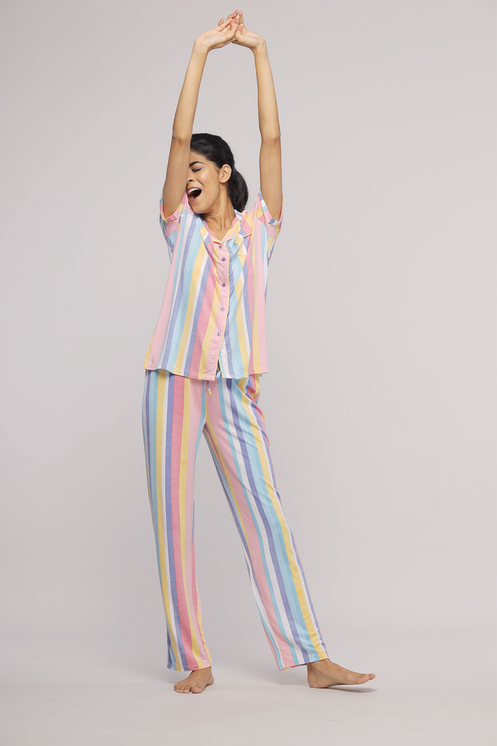 Pastel stripe pajama set modeled by a joyful young woman.