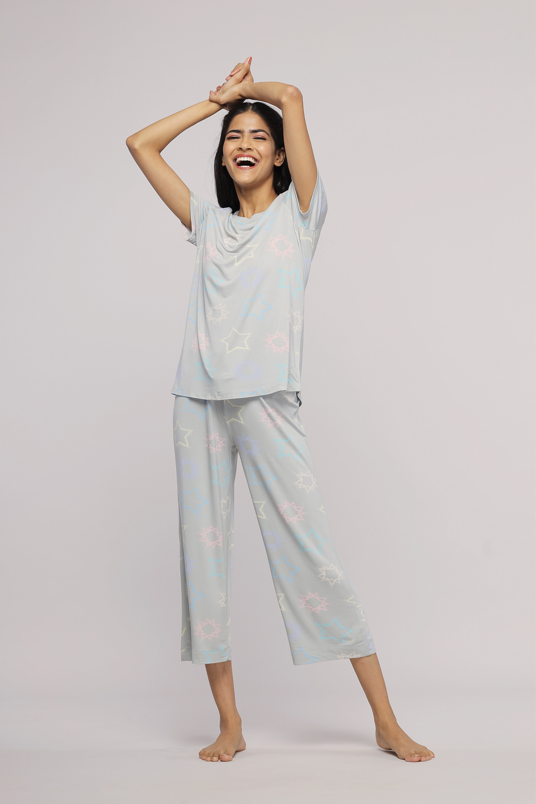 Woman wearing Starlit Capri Set, smiling in cheerful loungewear.