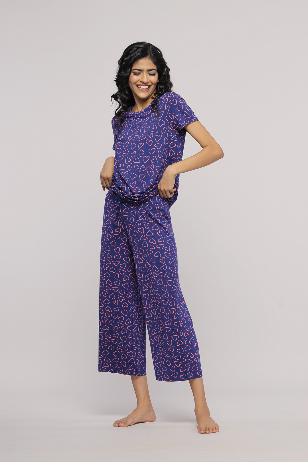 "Model wearing Sweetheart Capri pajama set with heart print design."