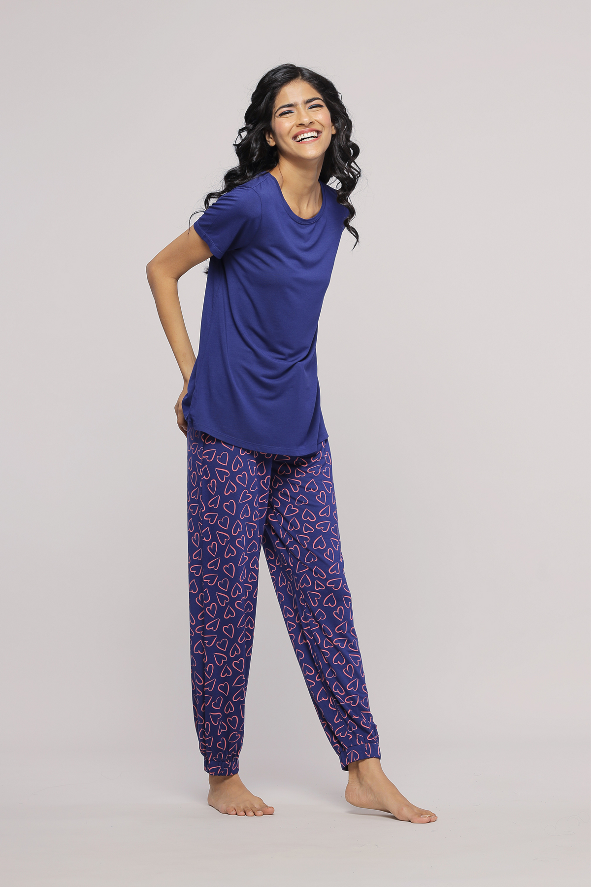 Smiling woman wearing Sweetheart Pajamas in blue and heart pattern.