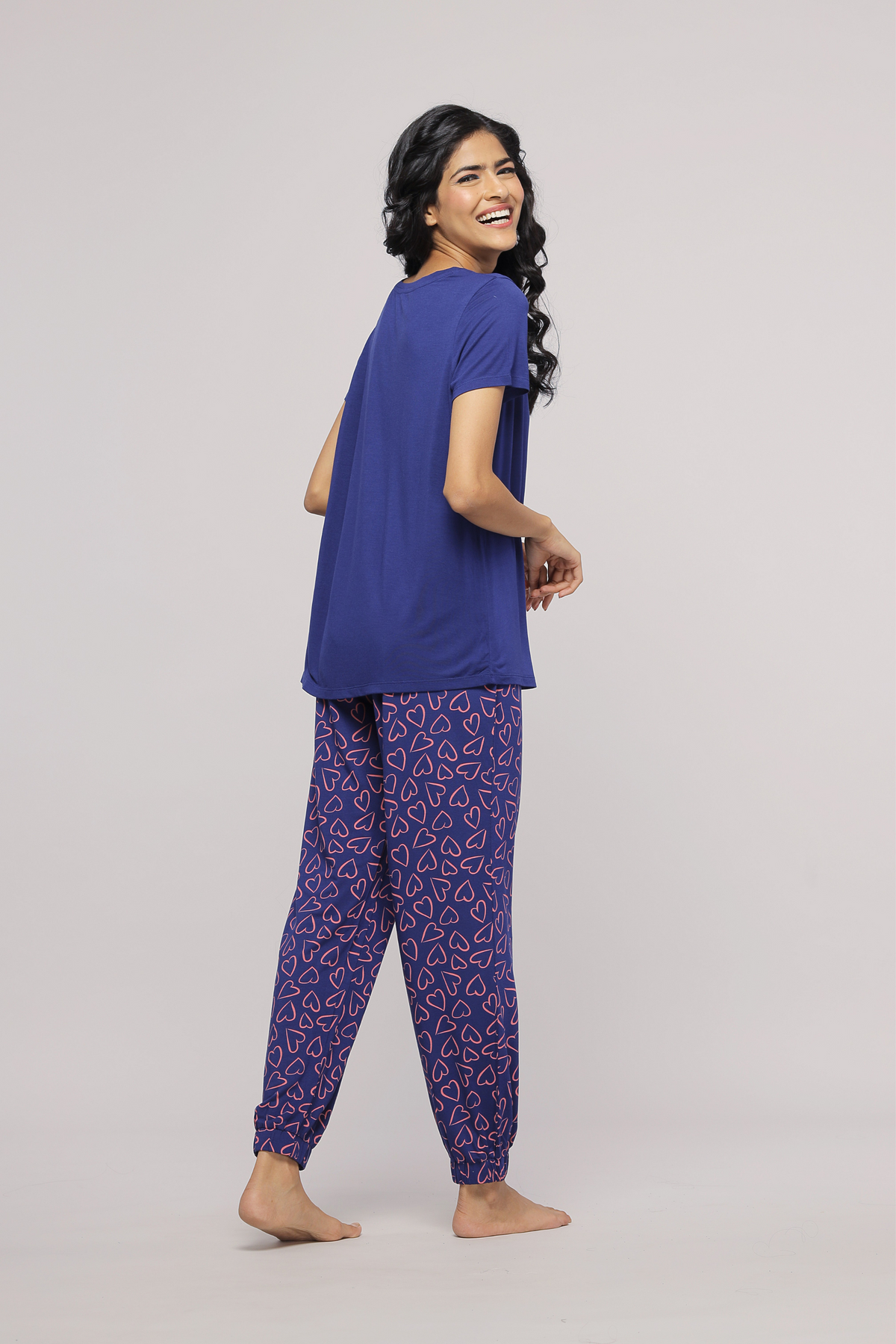 Model wearing Sweetheart Pajamas showcasing heart-patterned pants and comfortable top.