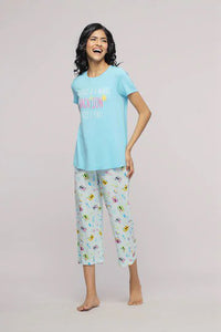 Smiling woman modeling The Voyager Capri Set in vibrant colors.