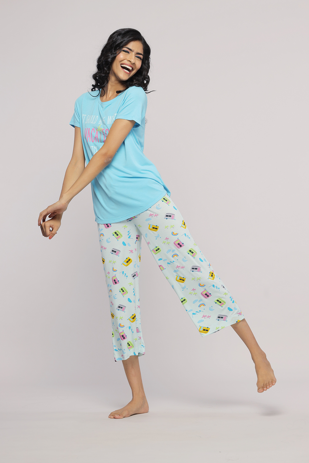 Smiling model in The Voyager Capri Set loungewear, showcasing vibrant print.