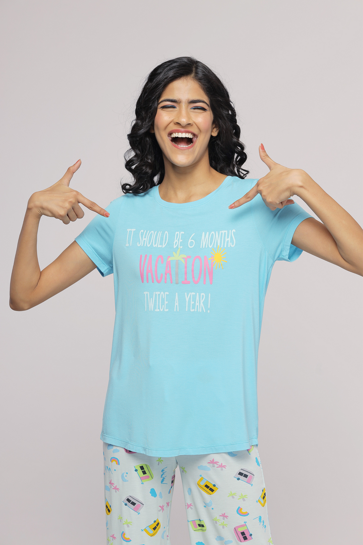 Happy model wearing blue "Vacation Top" with fun slogan.