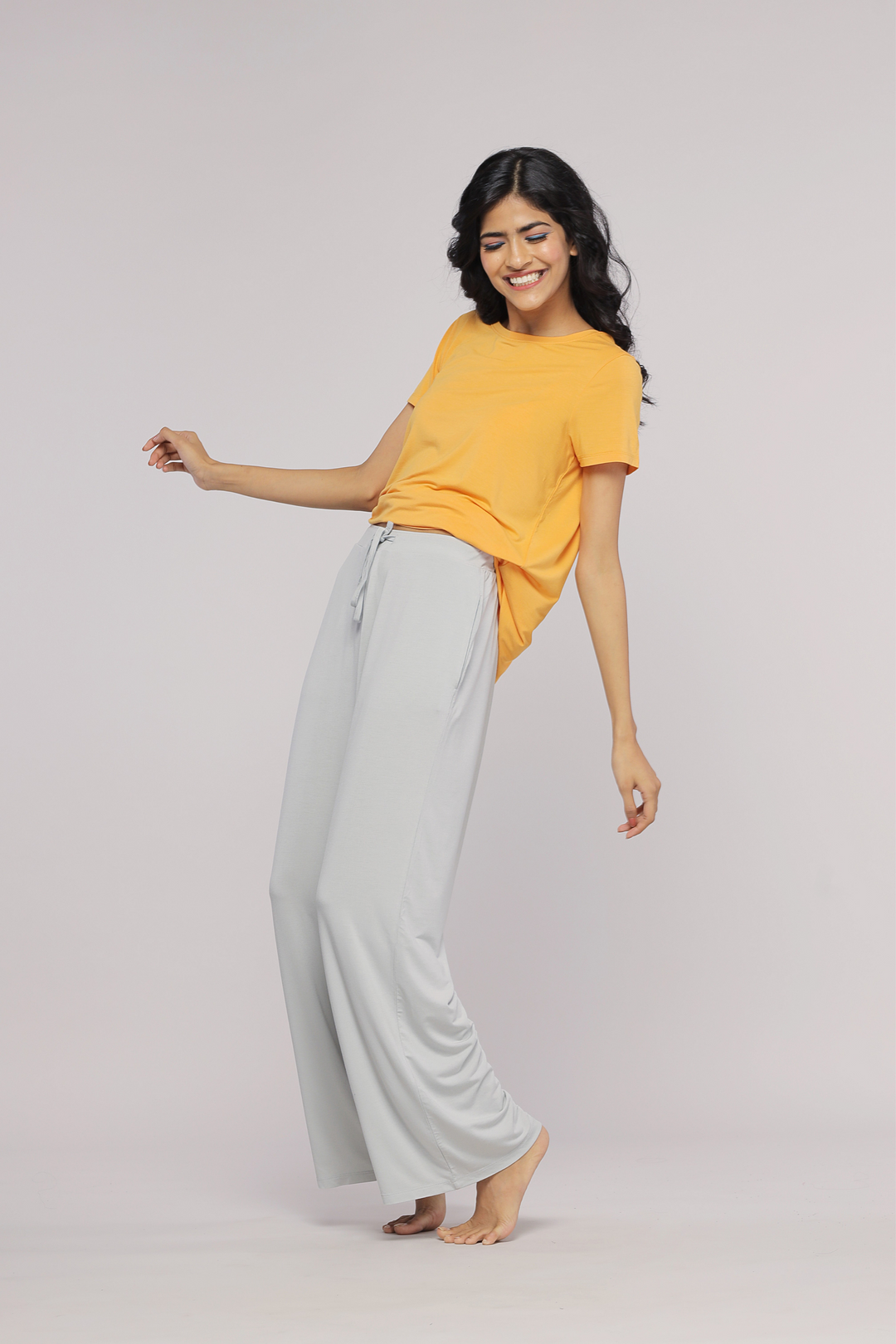 Model wearing Marigold Top with relaxed fit and light grey pants.