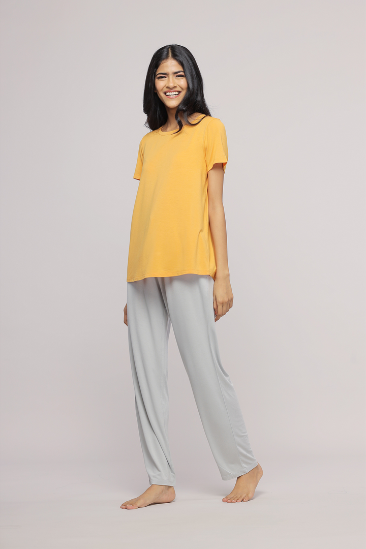 Stylish marigold top paired with light gray pants for women.