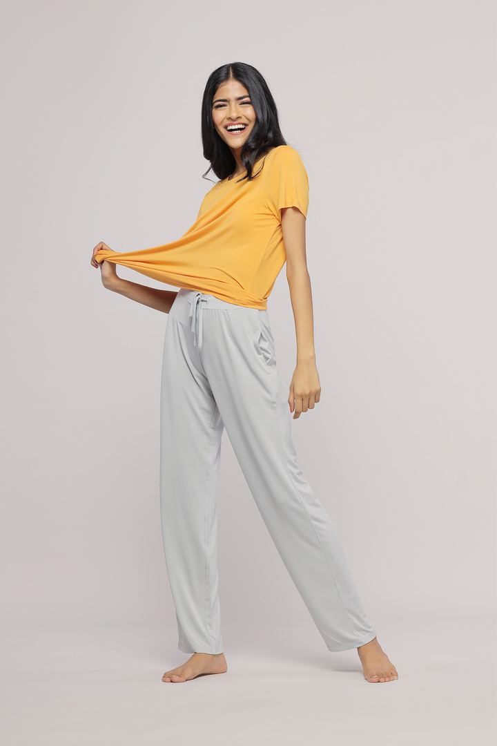 Smiling model wearing Marigold Top paired with light gray pants.